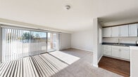 Located at 630 Pershing Blvd in Reading, PA, this 2-bedroom, 1-bathroom residence offers a well-designed single-floor layout with a clean, modern aesthetic. The combined kitchen and living room forms the heart of the home, where the living area is finished with plush carpet and bathed in natural light streaming through full-width sliding glass doors. These doors open to a balcony offering sweeping views of the surrounding hills, creating a bright and airy atmosphere. The kitchen is outfitted with white shaker-style cabinetry, gray countertops, stainless steel appliances including a gas range, microwave, and refrigerator, and durable hardwood-style flooring. The primary bedroom is generously proportioned, featuring carpet flooring, a sliding closet with built-in shelving, and its own sliding glass door for additional natural light. The full bathroom is tastefully appointed with a blue-gray vanity, white countertop, brushed nickel fixtures, a framed mirror, and a shower-tub combination, all set on wood-look tile flooring. A dedicated entrance and thoughtful layout complete this well-appointed residence in Reading, PA.