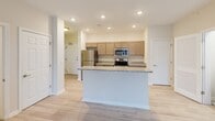 Located at 601-701 Water St in Seaford, Delaware, this well-appointed single-floor, 3-bedroom, 2-bathroom home offers a thoughtfully designed layout with modern finishes throughout. The open-concept kitchen serves as the heart of the home, featuring granite countertops, a central island with sink, light taupe cabinetry, and a full suite of stainless steel appliances including a refrigerator, electric range, microwave, and dishwasher. Light wood-style flooring runs through the main living areas, lending a clean and contemporary feel. The bright living room benefits from a sliding glass door that opens to an outdoor balcony, filling the space with natural light and providing outdoor views, and is complemented by a ceiling fan overhead. The spacious primary bedroom offers generous room to accommodate a variety of furniture arrangements. The additional bedrooms feature plush carpeting and natural light from windows. Two full bathrooms serve the home — one with a walk-in shower and the other with a full tub-shower combination, both finished in clean white tiling with chrome fixtures. A dedicated in-unit laundry room with full-size washer and dryer adds everyday convenience. The overall ambiance is fresh, neutral, and move-in ready.
