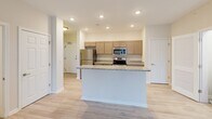 Located at 601-701 Water St in Seaford, Delaware, this well-appointed single-floor, 3-bedroom, 2-bathroom home offers a thoughtfully designed layout with modern finishes throughout. The open-concept kitchen serves as the heart of the home, featuring granite countertops, a central island with sink, light taupe cabinetry, and a full suite of stainless steel appliances including a refrigerator, electric range, microwave, and dishwasher. Light wood-style flooring runs through the main living areas, lending a clean and contemporary feel. The bright living room benefits from a sliding glass door that opens to an outdoor balcony, filling the space with natural light and providing outdoor views, and is complemented by a ceiling fan overhead. The spacious primary bedroom offers generous room to accommodate a variety of furniture arrangements. The additional bedrooms feature plush carpeting and natural light from windows. Two full bathrooms serve the home — one with a walk-in shower and the other with a full tub-shower combination, both finished in clean white tiling with chrome fixtures. A dedicated in-unit laundry room with full-size washer and dryer adds everyday convenience. The overall ambiance is fresh, neutral, and move-in ready.