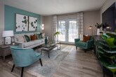Located at 1000 Country Oak Cir in Knoxville, Tennessee, this well-appointed single-story residence offers a cohesive and modern aesthetic throughout. The living room serves as the heart of the home, anchored by a striking teal accent wall adorned with botanical artwork and bathed in natural light from French doors that open to the outdoors. Wood-look flooring flows seamlessly through the space, complementing the warm, neutral tones on the walls.

The kitchen is both functional and stylish, featuring white upper cabinetry, contrasting gray lower cabinets, granite countertops, and stainless steel appliances including a range, microwave, and dishwasher. A pass-through window connects the kitchen to the adjacent dining area, which is cozy and inviting with a glass-top dining table and a large wall mirror that enhances the sense of space.

The bedrooms are generously sized, each equipped with ceiling fans, natural light from well-positioned windows, and coordinated teal and neutral décor. The primary bedroom features a tufted upholstered headboard and ample room to move comfortably. Additional bedrooms continue the cohesive design with ceiling fans and accent walls.

The bathroom offers granite countertops and clean, neutral finishes. A central hallway connects all areas of the home, creating a logical and comfortable flow throughout this thoughtfully designed residence.