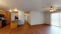Located at 2861 South Nettleton Avenue in Springfield, Missouri, this single-floor unit offers a well-organized and functional layout throughout. The open-concept living and dining area is finished with warm hardwood-style flooring that extends throughout the main living spaces, creating a cohesive and inviting atmosphere. A ceiling fan with a light fixture adds comfort to the living area, which also benefits from natural light through a sliding glass door.

The galley-style kitchen is well-appointed with warm wood cabinetry, dark granite countertops, and black appliances including a range, microwave, refrigerator, and dishwasher. The kitchen flows naturally into the main living space, making it ideal for everyday use and entertaining.

A hallway connects the living area to multiple carpeted bedrooms, each featuring ceiling fans with light fixtures and windows fitted with blinds that allow for natural light and privacy. The bedrooms provide generous proportions and a comfortable, quiet retreat.

The unit includes two full bathrooms, each with a tub-shower combination, toilet, and a vanity with a light countertop and white cabinetry. One bathroom features hardwood-style flooring, while both maintain a clean, neutral aesthetic. A walk-in closet is visible off one of the main rooms, adding practical storage to the overall layout.