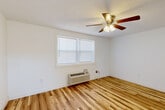 Located at 815 W Buford St in Gaffney, South Carolina, this single-story 2-bedroom, 1-bathroom home offers a practical and comfortable layout designed for efficient everyday living. Warm-toned hardwood flooring flows throughout the bedrooms and hallway, lending a cohesive and inviting feel to the interior.

Both bedrooms are bright and well-proportioned, each featuring a ceiling fan with light fixture, natural light from double-pane windows with blinds, and a dedicated closet with a rod for hanging storage. The primary bedroom also includes a wall-mounted HVAC unit for individual climate control.

The kitchen is equipped with light natural wood cabinetry — both upper and lower — complemented by light granite-style countertops, a stainless steel sink, a black gas range, over-the-range microwave, and a stainless steel refrigerator. White tile flooring and a window above the countertop complete the space, which also provides direct exterior access through a paneled door.

The bathroom features a white vanity with an integrated sink, a mirror, and light tile flooring that coordinates with the clean, neutral palette found throughout the home. A central hallway connects all rooms, providing an organized and efficient flow. The overall aesthetic is clean, bright, and move-in ready.