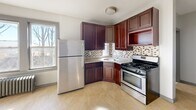Located at 12-16 Groton St in Hartford, Connecticut, this one-bedroom, one-bathroom unit offers a compact and efficient single-floor layout. The space is thoughtfully designed to maximize functionality throughout.

The kitchen is a standout feature, equipped with rich dark wood cabinetry, granite countertops, a mosaic tile backsplash, and stainless steel appliances including a gas range and full-size refrigerator. Light tile flooring and a window allowing natural light complete the space.

The bedroom is a comfortable size, featuring rich hardwood flooring, neutral warm-toned walls, and large double windows that bring in ample natural light with views of surrounding trees. A closet with a hanging rod provides convenient storage, and arched panel doors add a classic architectural touch throughout the unit.

The bathroom is elegantly finished with floor-to-ceiling marble-style tile, a decorative mosaic tile border, a pedestal sink, and a soaking tub with shower. A window above the tub allows for natural light and ventilation.

Overall, the unit presents a clean, updated aesthetic with consistent hardwood flooring in the living areas, classic panel doors with gray trim, and a neutral color palette that provides a bright and welcoming ambiance.