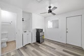 Located at 3942 8th Avenue in San Diego's vibrant Hillcrest neighborhood, this efficient one-bedroom, one-bathroom unit offers a thoughtfully designed layout making excellent use of its compact footprint. The main living area features light-toned, wood-look luxury vinyl plank flooring throughout, crisp white walls, and clean white trim that create a bright, modern aesthetic. A ceiling fan provides consistent airflow and overhead lighting. A window fitted with slatted blinds allows natural light to fill the space while maintaining privacy. The unit includes a stainless steel mini-refrigerator and microwave, providing essential kitchen conveniences. A white vanity with a sink and mirror is integrated into the main room, adding functional versatility. The bathroom is accessible directly from the main living area and features tile flooring, a walk-in shower stall equipped with grab bars for accessibility, and a toilet. The shower unit is white with a low-profile base. Overall, the unit presents a clean, move-in ready condition with a minimalist design approach, well-suited for single occupancy in one of San Diego's most walkable and amenity-rich urban neighborhoods.
