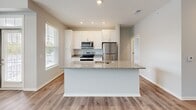 Located at 2331 Cadotte Dr SW in Wyoming, MI, this single-floor 2-bedroom, 2-bathroom residence offers a clean, modern design throughout. The open-concept layout seamlessly connects the living room, dining area, and kitchen, all finished with light wood-look flooring and neutral gray walls that create a bright, airy atmosphere. A ceiling fan and multiple windows allow natural light to fill the main living space. The kitchen is a standout feature, equipped with white shaker-style cabinetry, granite countertops, stainless steel appliances including a range, microwave, and refrigerator, and a central island with a sink — ideal for both cooking and casual dining. Both bedrooms are carpeted for comfort, with the spacious primary bedroom offering generous square footage and a ceiling fan. The second bedroom is equally well-sized with natural light from a window. Two full bathrooms feature granite-topped white vanities and tub-shower combinations with tile surrounds. A dedicated laundry room houses a full-size washer and dryer along with a water heater. Four closets provide ample storage throughout the home, completing this efficiently designed and move-in-ready residence.