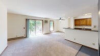 Located at 584 D'Onofrio Drive in Madison, Wisconsin, this single-floor, three-bedroom, one-bathroom unit offers a practical and well-organized layout. The open living and dining area is spacious and bright, featuring plush carpeting, a ceiling fan, and large sliding glass doors that lead to a balcony and flood the space with natural light and outdoor views of mature trees. Adjacent to the living area is a tile-accented fireplace, adding a standout focal point to the room. The kitchen is designed for efficiency, featuring warm wood cabinetry, dark granite countertops, a peninsula with a double sink, and stainless steel appliances including a refrigerator, range, and microwave. Tile flooring completes the kitchen area. The full bathroom is well-appointed with tile flooring, a tub-shower combination with tiled surround, a wood vanity, and a quartz countertop. Each of the three carpeted bedrooms is generously sized, with the primary bedroom offering ample closet space via a bifold-door closet. The additional bedrooms feature windows with outdoor views and their own closets. A connecting hallway ties all rooms together efficiently, rounding out a comfortable and functional living space.