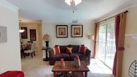 This single-floor residence at 51 Northtown Dr in Jackson, Mississippi offers a thoughtfully designed layout with a warm and inviting ambiance throughout. The living room serves as the heart of the home, featuring crown molding, a ceiling fan, and a classic wood-burning fireplace framed by a crisp white mantel. A sliding glass door floods the space with natural light and provides direct access to an outdoor balcony or patio, offering views of the surrounding area. The living area flows seamlessly into a dedicated dining space, which is accented by a pendant light fixture and tile flooring, providing an elegant setting for entertaining. The galley-style kitchen is efficiently arranged with white cabinetry trimmed in wood tones, laminate countertops, a stainless steel sink, and hardwood-style flooring that adds warmth underfoot. The bedrooms are carpeted and well-proportioned, each benefiting from natural light through large windows. The primary bedroom includes a ceiling fan and ample space. The bathrooms feature wood-tone cabinetry, generous countertop space, a large vanity mirror, and a combination tub and shower. Throughout the home, consistent warm-toned walls and crown molding details contribute to a cohesive and comfortable living environment.