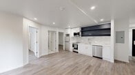 Located at 1201 Vine St in Philadelphia's vibrant Callowhill neighborhood, this thoughtfully designed 2-bedroom, 2-bathroom unit offers modern finishes throughout its efficiently arranged single-floor layout. Light-toned luxury vinyl plank flooring flows seamlessly across all living areas, complementing the clean white walls and recessed lighting that create a bright, contemporary atmosphere.

The open-concept kitchen is a standout feature, showcasing white shaker cabinetry, bold dark open shelving, a marble-style tile backsplash, white quartz countertops, and a full suite of stainless steel appliances including a refrigerator, range, built-in microwave, and dishwasher. The kitchen opens directly to the combined living and dining area, offering a functional and social layout.

Both bedrooms are well-proportioned, featuring wall-mounted mini-split HVAC units and dedicated closets. The primary bedroom includes an en-suite bathroom finished with floor-to-ceiling marble-style tile, a glass-enclosed walk-in shower, a wood-toned vanity with gold accents, and marble tile flooring. The second bathroom mirrors this elevated aesthetic with a soaking tub, matching marble tile surround, and a lit vanity mirror. A dedicated laundry area houses a stacked washer and dryer alongside an in-unit water heater, adding everyday convenience to this polished Philadelphia residence.