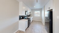 Located at 1221 W Miller Rd in Garland, TX, this single-story 2-bedroom, 1-bathroom home offers a clean, modern aesthetic throughout its thoughtfully designed floor plan. Light wood-look flooring flows consistently across all rooms, complementing the neutral gray walls and bright white trim that give the space a fresh, cohesive feel.

The kitchen is a standout feature, showcasing white shaker-style cabinetry with matte black hardware, a bold dark subway tile backsplash, light countertops, a stainless steel sink, and black appliances including a gas range and over-the-range microwave. A window above the sink area fills the kitchen with natural light and offers views of the surrounding area.

Both bedrooms are comfortably proportioned and include ceiling fans with light fixtures, windows with blinds for natural light and privacy, and white six-panel doors. The primary bedroom benefits from added closet space with a double-door closet. The second bedroom maintains the same clean finishes and bright atmosphere.

The bathroom is efficiently appointed with a tub/shower combo featuring white tile surround, matte black hardware and accessories, and a textured accent wall that adds depth to the space.

Throughout the home, consistent finishes and a neutral palette create a welcoming, move-in-ready environment well-suited for comfortable everyday living.