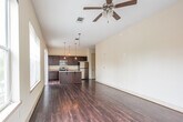 Located in the heart of downtown Montgomery, Alabama, this 2-bedroom, 2-bathroom residence at 79 Commerce St offers a well-appointed single-floor layout with a blend of modern finishes and urban convenience. The open-concept kitchen and living area serves as the centerpiece of the home, featuring rich dark wood cabinetry, granite countertops, a large kitchen island with a stainless steel sink, pendant lighting, and a full suite of stainless steel appliances. Dark hardwood flooring flows throughout the main living areas, adding warmth and continuity. Sliding glass doors lead to a private balcony with direct views of the vibrant downtown streetscape, filling the space with natural light. The primary bedroom is generously sized, complete with a ceiling fan and access to outdoor light through large windows. The second bedroom is carpeted and includes a closet, offering comfortable accommodation. Both bathrooms are finished with neutral tile flooring and tub-shower combinations with tile surrounds and dark wood vanities. A dedicated laundry area and in-unit mechanical systems add to the home's functionality. The overall ambiance is clean, modern, and urban, making it an ideal residence in the heart of Montgomery.