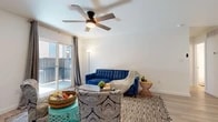 This well-appointed one-bedroom, one-bathroom unit offers a smart, functional layout across a single floor, making efficient use of every square foot. Light wood-style flooring flows consistently throughout the space, lending warmth and visual continuity from room to room.

The living room serves as the heart of the unit, featuring a ceiling fan, clean white walls, and a sliding glass door that opens to a private balcony, filling the space with natural light and providing outdoor views. The open layout accommodates comfortable seating arrangements and connects seamlessly to the rest of the unit.

The kitchen is outfitted with gray shaker-style cabinetry, a white quartz countertop island, a matte black faucet, and a full suite of appliances including a refrigerator and dishwasher — providing ample prep and storage space in a compact footprint.

The bedroom is a calm, well-proportioned retreat with a ceiling fan, a window with blinds for natural light control, and clean neutral walls. A dedicated closet offers practical storage.

The bathroom features a full tub-shower combination with white subway tile surround, complemented by brushed gold fixtures, wood-style flooring, and crisp white walls that create a clean, cohesive aesthetic throughout.