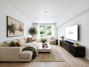 Bright living room with clean-lined furnishings, large windows, and an open layout that brings in natural light and connects to the surrounding neighborhood. - Modera Bridle Trails