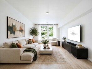 Bright living room with clean-lined furnishings, large windows, and an open layout that brings in natural light and connects to the surrounding neighborhood. - Modera Bridle Trails