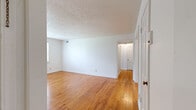 Located at 1317 W Grand River Ave in East Lansing, MI, this single-floor, 3-bedroom, 1-bathroom unit offers a practical and functional layout. Warm hardwood flooring flows consistently throughout the living areas and all three bedrooms, lending a cohesive and inviting feel to the space. The rooms are finished with clean white walls, textured ceilings, and white-trimmed panel doors, creating a bright and neutral interior. The spacious primary bedroom features a textured ceiling and is connected via hallways that efficiently link the rooms together. The additional bedrooms are well-sized, each with hardwood floors and windows that bring in natural light and views of the surrounding greenery. The kitchen is equipped with white upper cabinetry, a freestanding range, refrigerator, and a single-basin sink, all set on light tile flooring. The bathroom showcases a classic retro aesthetic with cream and black wall tiles, a mosaic tile floor, a wall-mounted sink, and a large window that provides natural light. Multiple hallways throughout the unit ensure smooth circulation between all areas. This unit offers a straightforward, functional design well-suited for everyday living in a convenient East Lansing location.