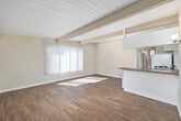 Located at 363 Palm Ave in the coastal community of Imperial Beach, California, this one-bedroom, one-bathroom unit offers a well-designed single-level layout with a warm and functional ambiance throughout. The living room is a standout space, featuring distinctive white-painted wood-plank ceilings with exposed beams that lend architectural character. Large vertical-blind windows bathe the room in abundant natural light, highlighting the warm wood-look flooring that flows seamlessly through the main living areas. The kitchen is efficiently arranged with white cabinetry, granite-look countertops, a gas range, a refrigerator, and a peninsula that opens toward the living space, creating an airy, connected feel. The bedroom offers plush carpeting, beamed ceilings consistent with the rest of the unit, and a generously sized mirrored sliding-door closet, along with a window that brings in natural light. The bathroom is clean and classic, featuring full white tile surrounding a tub-shower combo, a wood-toned vanity, and a window for ventilation. Compact yet thoughtfully laid out, this unit makes excellent use of its space and reflects a tidy, move-in-ready condition in a desirable Southern California beach community.