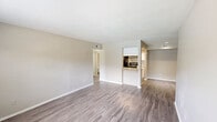 Located at 5907 Burning Tree Dr in Houston, TX, this single-floor 2-bedroom, 2-bathroom home offers a practical and well-appointed layout designed for comfortable everyday living. Wood-look plank flooring flows consistently throughout, complemented by neutral warm-gray walls that create a clean, cohesive aesthetic.

The kitchen is a standout feature, equipped with white shaker cabinetry with modern hardware, granite-look countertops, a tile mosaic backsplash, and black appliances including a refrigerator and electric range. A pass-through counter connects the kitchen to the living area, enhancing the open feel of the shared space. The living room is spacious and open, with direct sightlines into the kitchen, making it ideal for entertaining or daily use.

Both bedrooms are well-sized, each benefiting from natural light provided by large windows with exterior views. The primary bedroom includes an adjacent closet with built-in shelving for ample storage. A second closet is also present, and the hallway connects the rooms efficiently. Each bathroom features a tub-shower combo with white tile surround, granite-topped vanity, and wood-look flooring. The overall design is clean, functional, and move-in ready.