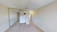 This 2-floor residence presents a straightforward and functional layout designed for comfortable everyday living. The bedroom showcased in the images is finished with wall-to-wall neutral-toned carpet, providing a soft and warm underfoot feel throughout the space. The room is generously sized, offering ample room for furnishings while maintaining an open, uncluttered feel.

A standout feature of the bedroom is the built-in closet system, which includes mirrored sliding doors that visually expand the space and enhance natural light reflection. Inside the closet, an open shelving unit with a dedicated hanging rod provides organized storage options. The mirrored panel adjacent to the closet further contributes to the room's sense of depth and brightness.

The walls are painted in a soft, neutral beige tone, creating a calm and versatile backdrop adaptable to various décor styles. A textured popcorn ceiling adds a classic finish overhead, complemented by a centrally located ceiling-mounted light fixture. Ventilation is provided through a ceiling air vent, ensuring consistent climate control. White baseboards frame the perimeter of the room, adding a clean, finished look throughout.