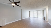 This well-appointed one-bedroom, one-bathroom residence at 11900 Edgewater Drive in Lakewood, Ohio, offers a comfortable and functional layout across a single floor. The spacious living room is a standout feature, showcasing light-toned hardwood-style flooring, a ceiling fan with integrated lighting, a textured ceiling, and floor-to-ceiling sliding glass doors dressed with vertical blinds that invite abundant natural light and outdoor views. The open layout connects seamlessly to a hallway leading to the remaining rooms. The kitchen has been thoughtfully updated with white shaker-style cabinetry, granite countertops, a classic subway tile backsplash, and stainless steel appliances including a dishwasher and range. The generously sized primary bedroom is carpeted for comfort and features large windows that bring in natural light, along with a textured ceiling. A dedicated closet provides ample storage with built-in wire shelving across multiple levels and carpeted flooring. The full bathroom includes a tiled tub-shower combination and tile flooring, maintaining a clean and functional aesthetic throughout. The overall ambiance of this residence is bright, neutral, and move-in ready, offering a practical and comfortable living environment in Lakewood.