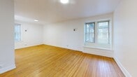Located at 21 Arnold Park in Rochester's desirable 14607 zip code, this 3-bedroom, 1-bathroom unit offers a practical and comfortable single-floor layout. Warm-toned hardwood floors run throughout the living areas and all three bedrooms, lending a classic and cohesive feel to the space. The living room is bright and welcoming, featuring a large window that draws in natural light, recessed lighting, and clean white walls with white-painted baseboards. Each bedroom is well-proportioned, with the primary bedroom offering a comfortable footprint, hardwood floors, and windows that provide views of the surrounding neighborhood. One bedroom features light tile flooring and dual windows that flood the room with sunlight. The kitchen is efficiently designed with white cabinetry including glass-front upper cabinets, dark granite-style countertops, white tile flooring, a gas range, built-in microwave, dishwasher, and a window above the sink for added brightness. The full bathroom is finished with classic white basketweave mosaic floor tile, a full soaking tub with shower, and a window for natural ventilation. A hallway connects the rooms, completing this well-organized and functional floor plan.