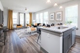 This single-floor residence at 3196 US-280 E in Birmingham, Alabama, presents a thoughtfully designed layout that balances modern aesthetics with practical functionality. The open-concept floor plan connects key living spaces seamlessly, creating a cohesive and comfortable environment throughout.

The kitchen serves as a central highlight, outfitted with gray shaker-style cabinetry, granite countertops, a white subway tile backsplash, and a full suite of stainless steel appliances. A peninsula with bar seating and pendant lighting adds both additional workspace and a casual dining option. Light hardwood-style flooring and generous natural light from a nearby window enhance the space's clean, contemporary feel.

The living area is generously proportioned, featuring multiple large windows that flood the room with natural light and views of the surrounding greenery. A ceiling fan and neutral wall tones contribute to a relaxed, welcoming ambiance.

The bedroom offers plush carpeting, multiple windows with natural light, and a ceiling fan, providing a calm and restful retreat. The adjoining bathroom includes a granite-topped vanity with an undermount sink, gray cabinetry, and a glass-enclosed shower.

A dedicated mudroom entry features built-in upper cabinetry, a bench, and ample storage, offering a practical and organized transition space into the home.