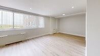 Located at 100 Old York Rd in Jenkintown, PA, this well-appointed 3-bedroom, 2-bathroom residence offers a clean, modern aesthetic throughout its single-floor layout. Light wood plank flooring flows seamlessly across the living room and bedrooms, complemented by crisp white walls, recessed lighting, and bright white baseboards that give the space a fresh, updated feel. The spacious living room provides an open, versatile area filled with natural light. Each bedroom is generously sized, with the primary bedroom offering ample room and access to a dedicated closet. Additional bedrooms feature large windows with vertical blinds, recessed lighting, and views of the surrounding area. A walk-in style closet with wire shelving provides excellent storage capacity. The kitchen is equipped with warm wood cabinetry, granite-style countertops, tile flooring, a gas range, built-in microwave, and a stainless steel refrigerator, offering both functionality and style. Two bathrooms serve the residence — one featuring a tiled shower/tub combination with a wood-toned vanity and granite countertop, and the second offering a walk-in tiled shower stall. A hallway connects the rooms efficiently, rounding out a well-organized and move-in-ready floor plan.