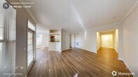 Located in Raleigh, NC, this single-story, 4-bedroom, 3-bathroom home offers a well-organized and functional floor plan filled with natural light. The entrance opens to a wide hallway with hardwood-style flooring that flows through the main living areas, guiding you toward a bright and airy living room accented by crown molding and a large window overlooking a balcony. The adjacent dining area connects seamlessly to the kitchen, which features warm wood cabinetry, dark granite-style countertops, a stainless steel dishwasher, and a pass-through window that enhances the open feel between spaces. The four bedrooms provide comfortable accommodations, with the primary bedroom offering generous proportions, plush carpeting, a ceiling fan, and access to a walk-in closet with wire shelving. The three bathrooms are well-appointed, each featuring wood vanities with dark countertops, bright vanity lighting, and tub-shower combinations with hardwood-style flooring. A dedicated laundry room houses a full-size washer and dryer with overhead wire shelving for added utility. Four closets throughout the home offer ample storage. The overall aesthetic is clean and neutral, with cream-toned walls, crisp white trim, and an abundance of windows that fill the space with warmth and light.