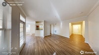 Located in Raleigh, NC, this single-story, 4-bedroom, 3-bathroom home offers a well-organized and functional floor plan filled with natural light. The entrance opens to a wide hallway with hardwood-style flooring that flows through the main living areas, guiding you toward a bright and airy living room accented by crown molding and a large window overlooking a balcony. The adjacent dining area connects seamlessly to the kitchen, which features warm wood cabinetry, dark granite-style countertops, a stainless steel dishwasher, and a pass-through window that enhances the open feel between spaces. The four bedrooms provide comfortable accommodations, with the primary bedroom offering generous proportions, plush carpeting, a ceiling fan, and access to a walk-in closet with wire shelving. The three bathrooms are well-appointed, each featuring wood vanities with dark countertops, bright vanity lighting, and tub-shower combinations with hardwood-style flooring. A dedicated laundry room houses a full-size washer and dryer with overhead wire shelving for added utility. Four closets throughout the home offer ample storage. The overall aesthetic is clean and neutral, with cream-toned walls, crisp white trim, and an abundance of windows that fill the space with warmth and light.