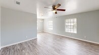 Located at 2400 Nordahl Dr in Augusta, Georgia, this single-story, 3-bedroom, 1-bathroom home offers a practical and comfortable layout. The open living area greets you with light gray walls, light-toned luxury vinyl plank flooring, multiple windows with blinds that invite ample natural light, and a ceiling fan with a built-in light fixture. A pendant light fixture marks the transition toward the kitchen area, adding a subtle design touch.

The galley-style kitchen is well-appointed with white cabinetry, granite-style countertops, a double stainless steel sink, a mosaic tile backsplash, and black appliances including an electric range with over-the-range microwave and refrigerator. The kitchen flows into a dedicated laundry area equipped with overhead wire shelving and hookups for a washer and dryer.

The spacious primary bedroom features plush carpeting, a ceiling fan, a generous closet, and a window with natural light. The two additional bedrooms are similarly finished with carpet, ceiling fans, and windows. One bedroom features vinyl plank flooring, offering versatility as a home office or flex space.

The full bathroom includes a tub/shower combo, a toilet, a vanity with storage, and wood-look vinyl flooring. A connecting hallway ties all rooms together in a cohesive, easy-to-navigate floor plan.