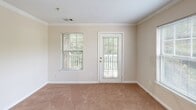 Located at 501 Downsby Ln in Woodstock, GA, this single-story, one-bedroom, one-bathroom residence offers a practical and comfortable layout across a single level. The combined kitchen and living area forms the heart of the home, where the living room is finished with crown molding, warm neutral tones, and plush carpeting throughout. Natural light fills the space via multiple windows dressed with blinds, and a glass-paneled door opens directly to a private outdoor deck, offering a pleasant connection to the exterior. The kitchen is a functional galley-style space featuring light wood cabinetry, a white countertop with an integrated sink, and white appliances including a refrigerator and dishwasher. Wood-look tile flooring grounds the kitchen and adds durability to the space. The bedroom is generously sized, carpeted, and equipped with a ceiling fan for year-round comfort. A large window frames lush greenery outside, creating a serene atmosphere. Two closets provide ample storage throughout the unit. The bathroom features wood-look tile flooring, light wood vanity cabinetry, and a tiled shower, maintaining the clean, neutral aesthetic found throughout the home. A hallway connects the rooms, completing this well-organized and inviting residence.