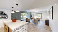 This 400 square foot space in Tucson, Arizona, showcases a modern, open-concept design that maximizes functionality and style. The kitchen is a standout feature, boasting light wood cabinetry, a sage green tile backsplash, and stainless steel appliances. A unique island with decorative cutout panels serves as both a workspace and casual dining area, complete with contemporary bar stools.

The living area seamlessly connects to the kitchen, creating a fluid, spacious feel. It's furnished with comfortable, neutral-toned seating arranged around a wooden coffee table. Large windows flood the space with natural light and offer views of the surrounding landscape, bringing the outdoors in.

Throughout the space, herringbone pattern wood flooring adds warmth and visual interest. The lighting is a mix of recessed lights and statement pendant fixtures, including a striking circular chandelier in the living area. Thoughtful decor touches, such as potted plants, artwork, and decorative objects, complete the sophisticated yet inviting ambiance of this compact yet well-designed living space.