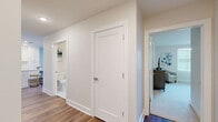 Located at 4301 Old William Penn Highway in Pittsburgh, PA, this single-floor residence offers two bedrooms, two bathrooms, and two closets within a thoughtfully designed layout. The open-concept kitchen is a standout feature, showcasing white shaker cabinetry, a subway tile backsplash, stainless steel appliances, recessed lighting, and a white island with bar seating — all set atop warm hardwood-style flooring. The adjoining living room is bright and welcoming, with large windows that invite natural light and provide outdoor views. The primary bedroom is generously sized, offering plush carpeting, multiple windows, and ample natural light. The second bedroom is equally versatile, with neutral tones and access to a closet. Both bathrooms feature a classic black-and-white mosaic tile floor, white vanities with dual sinks, and a tub-shower combination, delivering a clean and timeless aesthetic. A hallway connects the bedrooms and bathrooms with crisp white panel doors and hardwood-style flooring throughout. The private covered balcony features exposed wood-beam ceilings and stone pillar accents, offering a comfortable outdoor retreat. The overall ambiance is modern, clean, and move-in ready.