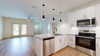 Located at 411 Sage Rd N in White House, Tennessee, this well-appointed one-bedroom, one-bathroom unit offers a thoughtfully designed single-floor layout. The open-concept kitchen and living area serves as the heart of the home, where light wood-look flooring, crisp white walls, and a ceiling fan create a bright and airy atmosphere. French doors in the living area invite natural light and provide outdoor access, while an additional window further enhances the sense of openness.

The kitchen is a standout feature, showcasing white shaker cabinetry with matte black hardware, a granite-topped peninsula with an undermount sink, and a full suite of stainless steel appliances including a refrigerator, range, microwave, and dishwasher. Stylish black pendant lights hang above the peninsula, adding a modern touch.

The bedroom offers comfortable plush carpeting, a ceiling fan, and a window with outdoor views, creating a calm and restful retreat. A dedicated closet provides convenient storage. The bathroom includes a granite-topped vanity with white cabinetry, a tub/shower combo with tile surround, and wood-look flooring. A separate laundry room houses a full-size washer and dryer, completing this functional and modern living space.