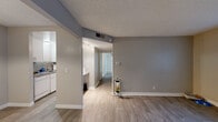 Located at 3675 Cambridge St in Las Vegas, Nevada, Unit P227 is a single-floor residence that offers a clean, functional layout designed for comfortable everyday living. The open living area is finished with wood-style plank flooring and neutral gray walls, creating a cohesive and modern aesthetic throughout. A textured ceiling adds a classic touch, while vertical blinds on the large windows allow for adjustable natural light and views of the surrounding area.

The kitchen is efficiently arranged with white cabinetry, granite-look countertops, a tile backsplash, and a freestanding electric range, providing all the essentials for meal preparation. A pass-through partition visually connects the kitchen to the main living space, enhancing the open feel of the floor plan.

A central hallway, illuminated by track lighting, leads to the private areas of the unit. The bedrooms feature the same wood-style flooring, neutral tones, and sliding closet doors for practical storage. Each room benefits from windows fitted with vertical blinds that invite natural light while maintaining privacy.

The bathroom is outfitted with a white vanity, a solid-surface countertop with an integrated sink, a framed mirror, and ample storage. Throughout the unit, clean white baseboards and consistent finishes contribute to a well-maintained and move-in ready presentation.