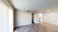 This single-story residence in Hattiesburg, Mississippi, offers a thoughtfully arranged 1-bedroom, 1-bathroom floor plan. The living area features rich dark hardwood-style flooring, neutral-toned walls, and a textured ceiling. A sliding glass door with vertical blinds fills the space with natural light while providing access to the outdoors. The layout flows seamlessly into a dining or transitional area, also finished with wood-style flooring, leading directly to the kitchen.

The galley-style kitchen is well-appointed with white shaker cabinetry, granite-look countertops, subway tile backsplash, stainless steel appliances including a refrigerator, microwave, electric range, and dishwasher, along with a stainless steel sink — all illuminated by a skylight-style overhead fixture and light wood-tone flooring.

The bedroom is carpeted for comfort and features a ceiling fan with light fixture, a natural-light window with blinds, and a walk-in closet, providing ample storage. The bathroom includes a full soaking tub and shower combination with clean white subway tile surround and brushed nickel fixtures.

Throughout the home, consistent neutral tones, clean finishes, and a practical layout create a comfortable and functional living environment.