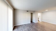 This single-story residence in Hattiesburg, Mississippi, offers a thoughtfully arranged 1-bedroom, 1-bathroom floor plan. The living area features rich dark hardwood-style flooring, neutral-toned walls, and a textured ceiling. A sliding glass door with vertical blinds fills the space with natural light while providing access to the outdoors. The layout flows seamlessly into a dining or transitional area, also finished with wood-style flooring, leading directly to the kitchen.

The galley-style kitchen is well-appointed with white shaker cabinetry, granite-look countertops, subway tile backsplash, stainless steel appliances including a refrigerator, microwave, electric range, and dishwasher, along with a stainless steel sink — all illuminated by a skylight-style overhead fixture and light wood-tone flooring.

The bedroom is carpeted for comfort and features a ceiling fan with light fixture, a natural-light window with blinds, and a walk-in closet, providing ample storage. The bathroom includes a full soaking tub and shower combination with clean white subway tile surround and brushed nickel fixtures.

Throughout the home, consistent neutral tones, clean finishes, and a practical layout create a comfortable and functional living environment.