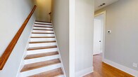 Located at 1012 Grey Oak Pvt Ln in Franklin, TN, this well-appointed three-story home offers four bedrooms and four bathrooms across a thoughtfully designed layout. Warm hardwood flooring flows throughout all levels, lending a cohesive and inviting character to the space.

The main living level features an open-concept kitchen and living area bathed in natural light from multiple windows. The kitchen is outfitted with white shaker cabinetry, a large waterfall-edge island with an undermount sink, stainless steel appliances, subway tile backsplash, and elegant glass pendant lighting. A glazed door opens to an exterior balcony, extending the living space outdoors.

The bathrooms are finished with clean, modern details including subway-tiled walk-in showers with herringbone-patterned floors, glass enclosures, and white vanities with quartz countertops set on slate tile flooring.

Each bedroom features hardwood floors and ample natural light. The primary bedroom is generously sized and includes a walk-in closet with built-in wire shelving. A standout upper-level bedroom showcases vaulted ceilings with a rustic ceiling fan, adding architectural interest. Soft gray-toned walls throughout create a calm, neutral palette that complements the home's modern yet warm aesthetic.