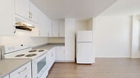 This 700 square foot apartment in Los Angeles offers a modern and efficient living space. The single-story layout features two bedrooms, including a primary bedroom of 130 square feet, and one bathroom. The open floor plan creates a sense of spaciousness, with the kitchen seamlessly integrated into the living area. 

The kitchen is equipped with white cabinetry, providing ample storage, and includes essential appliances such as a refrigerator and stove. Light-colored wood-look flooring extends throughout the apartment, contributing to a bright and airy atmosphere. Large windows with vertical blinds allow natural light to flood the rooms, enhancing the overall ambiance.

The bathroom showcases a clean, contemporary design with a white vanity, mirror, and a bathtub-shower combination. A closet with wire shelving systems offers organized storage space. The apartment's neutral color palette, predominantly featuring white walls, creates a blank canvas for personalization.

This compact yet well-designed apartment exemplifies efficient urban living, making smart use of its 700 square feet to provide comfortable, modern accommodations in the heart of Los Angeles.