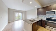 Located at 5608 Gavin Way in Virginia Beach, VA, this one-bedroom, one-bathroom unit offers a thoughtfully designed layout across a single floor. The open-concept living and kitchen area creates a cohesive, functional space highlighted by light wood-style flooring and a neutral color palette throughout.

The kitchen is a standout feature, equipped with rich dark-espresso cabinetry, a mosaic tile backsplash, granite countertops, and a full suite of stainless steel appliances including a range, microwave, dishwasher, and refrigerator. A peninsula with an integrated sink provides additional prep space and serves as a natural divider between the kitchen and living area.

The living room is bright and open, benefiting from natural light and French doors that lead to a private balcony overlooking the surrounding community and water views. The bedroom offers plush carpeting, a ceiling fan with light fixture, and a generously sized window that brings in additional natural light. A dedicated closet provides practical storage.

The bathroom includes a full soaking tub with a clean, white surround. Overall, the unit presents a modern, move-in-ready aesthetic with consistent finishes throughout.