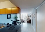 Located at 1750 N Bayshore Drive in Miami, FL, this contemporary residence offers a thoughtfully designed single-floor layout that blends modern aesthetics with functional living. The open-concept living and dining area is anchored by large floor-to-ceiling windows and sliding glass doors that flood the space with natural light and frame sweeping views of the surrounding Miami skyline. Light-toned porcelain tile flooring flows throughout the main living areas, lending a clean, cohesive feel.

The kitchen is equipped with stainless steel appliances, dark granite countertops, warm wood cabinetry that extends to the ceiling, and a breakfast bar with modern seating — ideal for casual dining or entertaining. The seamless connection between the kitchen and living area enhances the overall open feel of the home.

The bedroom is a serene retreat featuring plush carpeting, a ceiling fan, and its own set of floor-to-ceiling windows with city views. The bathroom includes a soaking tub and shower combination with full tile surround and a curved curtain rod.

A secondary space off the main living area provides additional flexibility, with carpeting and curated artwork adding warmth and character. Throughout the residence, a neutral color palette, contemporary furnishings, and abundant natural light create a refined urban atmosphere.