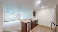 This 2-bedroom, 1-bathroom single-floor residence in Saint Cloud, Minnesota offers a well-organized layout designed for comfortable everyday living. The open-concept kitchen, dining, and living area serves as the heart of the home, featuring light hardwood-style flooring, dark espresso cabinetry, granite-look countertops, a peninsula with a double sink, and a full suite of stainless steel appliances including a refrigerator, range, microwave, and dishwasher. Recessed lighting illuminates the kitchen, while the adjacent living area is finished with plush carpet, a ceiling fan, and a large window that brings in natural light and outdoor views. A glass-panel door provides direct access to the private patio. Both bedrooms are carpeted and include dedicated closets for storage, with the primary bedroom featuring a ceiling fan and generous proportions. The second bedroom also offers closet space and easy access to the shared full bathroom, which includes a tub/shower combination. A conveniently located in-unit laundry area adds practical functionality. Throughout the residence, neutral tones, clean lines, and consistent finishes create a bright, cohesive living environment.