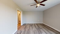 Located at 11401 Mesa Dr in Little Rock, Arkansas, this single-floor residence offers a well-designed layout with consistent, modern finishes throughout. The interior showcases durable luxury vinyl plank flooring in the main living areas, complemented by neutral-toned walls that create a clean and inviting atmosphere.

The kitchen is thoughtfully appointed with white shaker-style cabinetry, granite-look countertops, a stainless steel sink with a gooseneck faucet, and a full suite of appliances including a refrigerator, range, and dishwasher. Ample cabinet storage lines both walls of the galley-style kitchen, maximizing functionality.

The bedrooms offer comfortable living spaces, each equipped with ceiling fans for year-round comfort. One bedroom features smooth luxury vinyl plank flooring and direct access to an adjoining room, while another is finished with plush carpeting and a built-in closet. A standout bedroom includes sliding glass doors that open to a private balcony, flooding the space with natural light and providing pleasant outdoor views of the surrounding landscape.

The bathroom is finished with wood-look flooring, a white vanity with granite-style countertops, and a full tub-shower combination with built-in shelving. Clean white fixtures and brushed nickel hardware complete the polished look. Overall, the space presents a cohesive, move-in-ready aesthetic with practical, well-maintained finishes throughout.