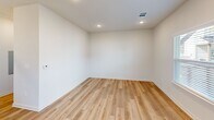 Located at 544 Olympic Drive in Portland, Texas, this two-story home offers a thoughtfully designed layout spread across two floors. The main level provides a welcoming living area bathed in natural light from multiple windows, featuring light wood-look flooring and clean white walls that create a bright, open atmosphere. The kitchen is a standout feature, showcasing gray shaker-style cabinetry with black hardware, crisp white quartz countertops, a large center island with a modern pendant light fixture, and a full suite of stainless steel appliances. Light hardwood flooring ties the kitchen and living spaces together seamlessly. A convenient half bathroom on the main level features the same warm flooring and a clean, minimalist design. The attached garage offers ample space with an automatic opener and overhead lighting. Upstairs, two carpeted bedrooms each include ceiling fans and windows that invite natural light. The generously sized primary bedroom provides a comfortable retreat. Three bathrooms in total serve the home, including one with a tub-shower combo featuring white tile surround and chrome fixtures. A hallway, closet, and staircase complete the well-organized floor plan, making this home both functional and stylish throughout.