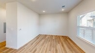 Located at 544 Olympic Drive in Portland, Texas, this two-story home offers a thoughtfully designed layout spread across two floors. The main level provides a welcoming living area bathed in natural light from multiple windows, featuring light wood-look flooring and clean white walls that create a bright, open atmosphere. The kitchen is a standout feature, showcasing gray shaker-style cabinetry with black hardware, crisp white quartz countertops, a large center island with a modern pendant light fixture, and a full suite of stainless steel appliances. Light hardwood flooring ties the kitchen and living spaces together seamlessly. A convenient half bathroom on the main level features the same warm flooring and a clean, minimalist design. The attached garage offers ample space with an automatic opener and overhead lighting. Upstairs, two carpeted bedrooms each include ceiling fans and windows that invite natural light. The generously sized primary bedroom provides a comfortable retreat. Three bathrooms in total serve the home, including one with a tub-shower combo featuring white tile surround and chrome fixtures. A hallway, closet, and staircase complete the well-organized floor plan, making this home both functional and stylish throughout.
