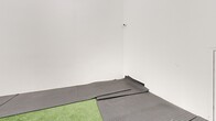 Located at 75 Charolais Blvd in Brampton, Ontario, this single-room space offers a practical and functional layout well-suited for athletic training, fitness, or recreational use. The room is enclosed by clean, white-painted walls that create a bright and open ambiance, complemented by recessed linear lighting mounted along the upper perimeter that ensures consistent illumination throughout the space.

The floor is finished with a combination of artificial green turf at the centre and dark grey textured rubber matting along the perimeter. This dual-surface configuration supports a variety of activities, offering the cushioning and traction needed for both agility drills and general exercise. A transom-style window is positioned near the ceiling on one wall, allowing a degree of natural light to filter in while maintaining wall space below. A white access door is also visible along one wall, providing entry to the room.

The space is thoughtfully proportioned, offering ample room for movement and versatile training configurations. The minimalist, uncluttered design keeps the focus on functionality, making it a highly adaptable environment for fitness instruction, athletic conditioning, or similar active uses. The white walls and clean finishes contribute to a fresh, professional atmosphere appropriate for a commercial or shared-use facility setting.