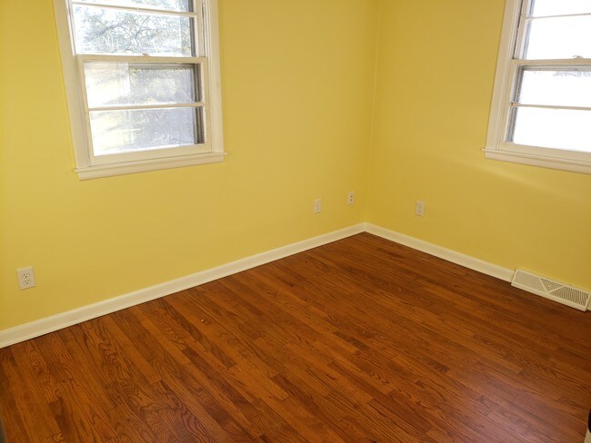 Dormitorio trasero más pequeño con suelo de madera y mucha luz. - 6452 Washington Ave