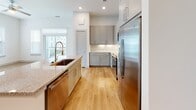Located at 3118 County Road 172 in Round Rock, TX, this single-story home offers a clean, modern design with an open-concept layout that seamlessly connects the main living areas. Light hardwood flooring flows throughout the common spaces, complemented by recessed lighting and crisp white walls that create a bright, airy atmosphere.

The kitchen is a standout feature, showcasing gray shaker-style cabinetry, granite countertops, a large center island with an undermount sink, and a full suite of stainless steel appliances including a refrigerator, range, microwave, and dishwasher. A built-in coat rack and bench near the entryway provide a convenient mudroom-style drop zone.

The bedrooms are carpeted for comfort and include well-organized closets with built-in shelving and hanging rods. The primary suite connects to a bathroom and a walk-in closet. The bathrooms feature granite vanity tops, gray cabinetry, and wood-look flooring, with one bath offering a tiled tub/shower combination and another featuring a glass-enclosed shower. Natural light enters through multiple windows fitted with blinds, offering views of the surrounding neighborhood. The home's neutral palette and thoughtful finishes throughout make it a move-in-ready residence in the Round Rock area.