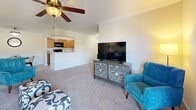 Located at 121 Breighton Cir in Shelbyville, Kentucky, this single-floor, two-bedroom, two-bathroom home offers a well-organized and functional layout. The open-concept living and kitchen area forms the heart of the home, where the living room features plush carpet, crown molding, and a ceiling fan, with a door providing direct access to an outdoor space. The adjoining kitchen is appointed with warm wood cabinetry, granite-style countertops, hardwood-style flooring, and black appliances including a range, microwave, and refrigerator, with a view into a small dining area. The primary bedroom is a comfortable retreat with carpet flooring, a window allowing in natural light, and generous proportions. The second bedroom mirrors this warmth with carpet, a window, and ample space. Two full bathrooms serve the home; one features tile flooring and a walk-in shower, while the second offers a white vanity with a large mirror. A dedicated laundry room houses a full-size washer and dryer with overhead shelving. Two closets and a hallway complete the layout, offering practical storage throughout. The home delivers a cozy, well-appointed living experience in a residential Shelbyville neighborhood.
