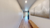 Located on the sixth floor at 513 1st Ave N in Seattle's Lower Queen Anne neighborhood, this thoughtfully designed one-bedroom, one-bathroom residence offers a well-organized layout across a single floor. Light wood-tone flooring flows consistently throughout the unit, lending a clean and cohesive aesthetic.

The entry corridor welcomes you with recessed lighting and a bright, airy feel, opening into the combined kitchen and living area. The modern kitchen features two-tone cabinetry with warm wood uppers and dark lower cabinets, a white quartz countertop, subway tile backsplash, a matte black sink faucet, and stainless steel appliances including a full-size refrigerator and dishwasher. The adjacent living room is bathed in natural light from floor-to-ceiling sliding glass doors that lead to a private balcony overlooking the Seattle cityscape.

A dedicated office off the living area offers large windows with urban views and a double-door closet, providing functional flexibility. The bedroom is a cozy, well-proportioned retreat. The full bathroom features a sleek dark vanity with quartz countertop, an undermount sink, and matte black fixtures. Clean white walls and recessed lighting complete the modern, minimalist interior throughout.
