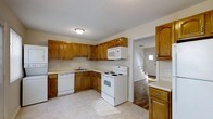 Located at 99 Hemingway Ave in East Haven, Connecticut, this two-bedroom, one-bathroom townhouse spans two floors, offering a comfortable and functional living environment. The kitchen is well-appointed with warm oak cabinetry providing generous storage, light countertops, and a full suite of white appliances including a range, built-in microwave, and dishwasher. A double-basin sink sits beneath a window, and the light tile flooring keeps the space bright and easy to maintain. The kitchen opens with a clear sightline to the entryway and staircase, creating a connected flow between the main living areas. The entry foyer showcases rich hardwood flooring that extends into the adjoining spaces, adding warmth and character to the home. A staircase leads to the upper floor, where the two bedrooms are situated, offering privacy separate from the main living areas below. The home's neutral color palette throughout creates a clean, move-in-ready atmosphere. With its classic layout, ample cabinetry, and durable finishes, this townhouse provides a practical and welcoming living space in the East Haven community.