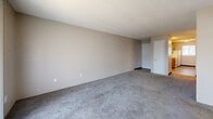 Located at 2803 S Emporia St in Wichita, KS, this apartment offers a well-organized single-floor layout comprising two bedrooms, two full bathrooms, a kitchen, and a dedicated closet. The kitchen is outfitted with warm oak cabinetry, white appliances including a refrigerator, range, and dishwasher, light countertops, a double-basin sink, and durable wood-look vinyl flooring. A window above the sink allows natural light to filter in, providing views of surrounding greenery. The spacious living area features neutral-toned carpet and a textured ceiling, creating a clean and understated atmosphere. Both bedrooms are carpeted and finished with neutral walls and textured ceilings, each with access to natural light through windows. The primary bedroom includes an attached closet and direct access to one of the full bathrooms, which features a full tub-shower surround and oak overhead cabinetry. The second bedroom also benefits from natural light and comfortable proportions. A second full bathroom mirrors the first in design, maintaining consistency throughout. The overall layout is straightforward and efficient, making practical use of the available space across the unit.